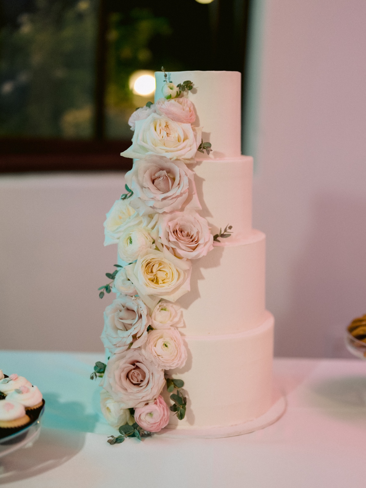 four tiered wedding cake with live rose details