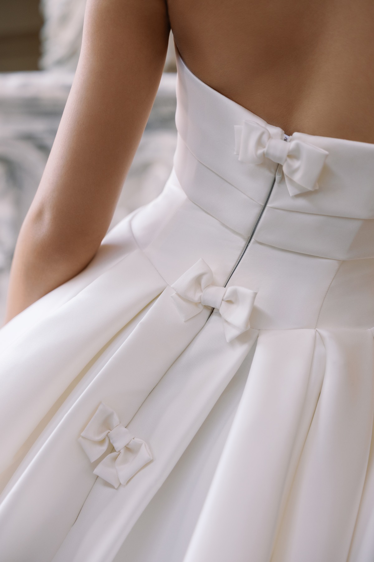 close up shot of wedding dress with small bows
