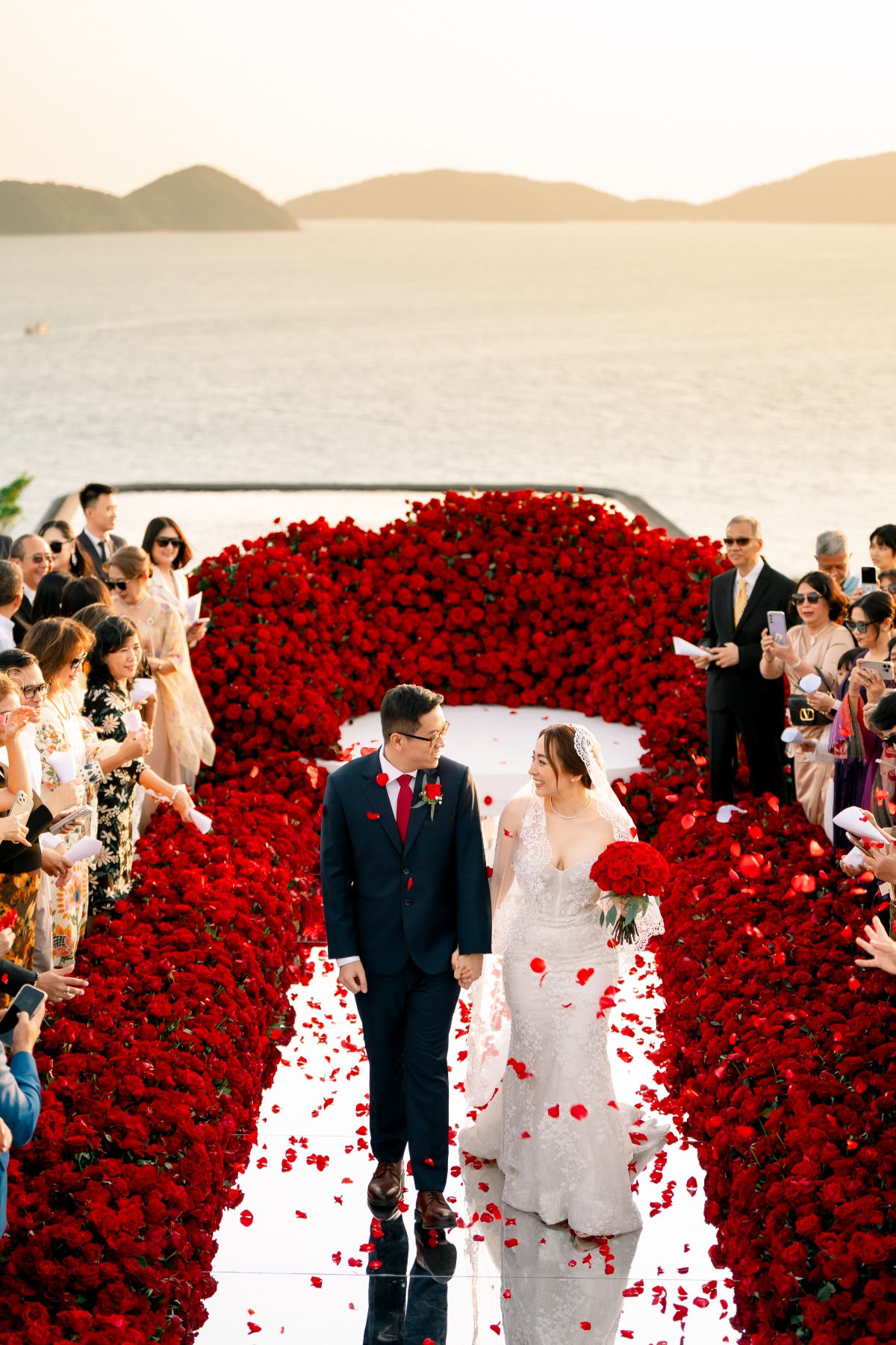 wall of red roses down wedding aisle