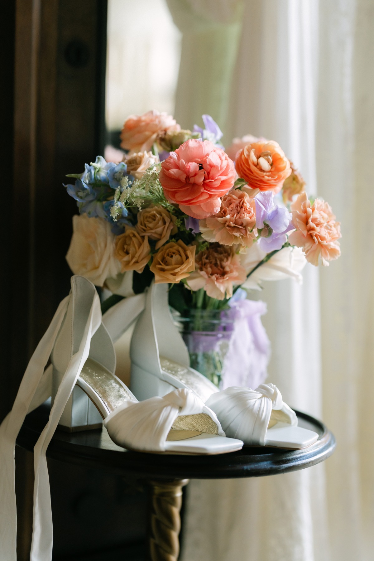 bridal bouquet and wedding shoes on table