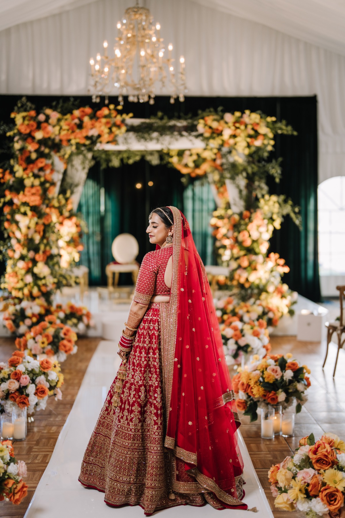 indian bride in red walking down the aisle
