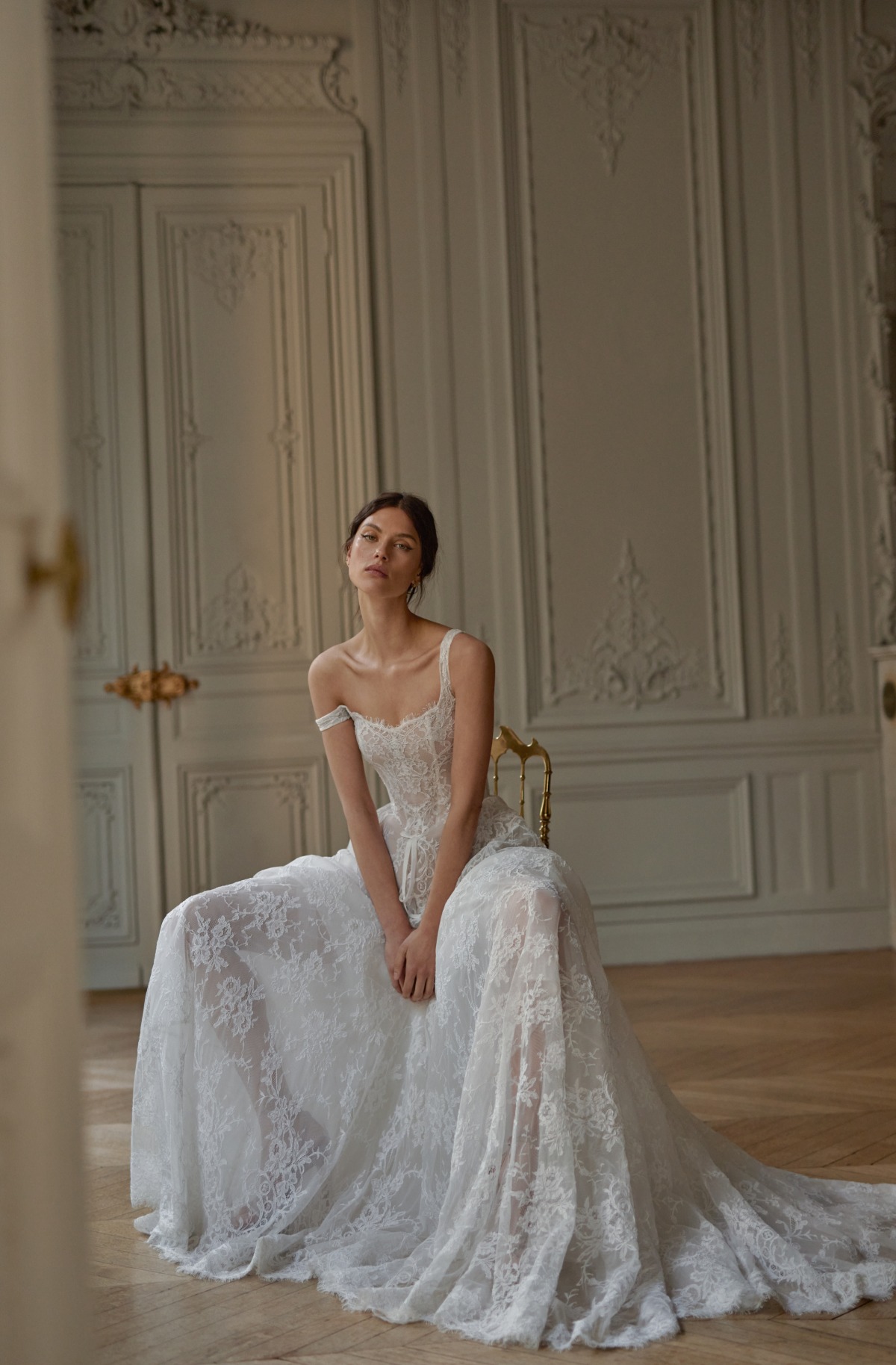 bride sitting on chair in lace wedding dress