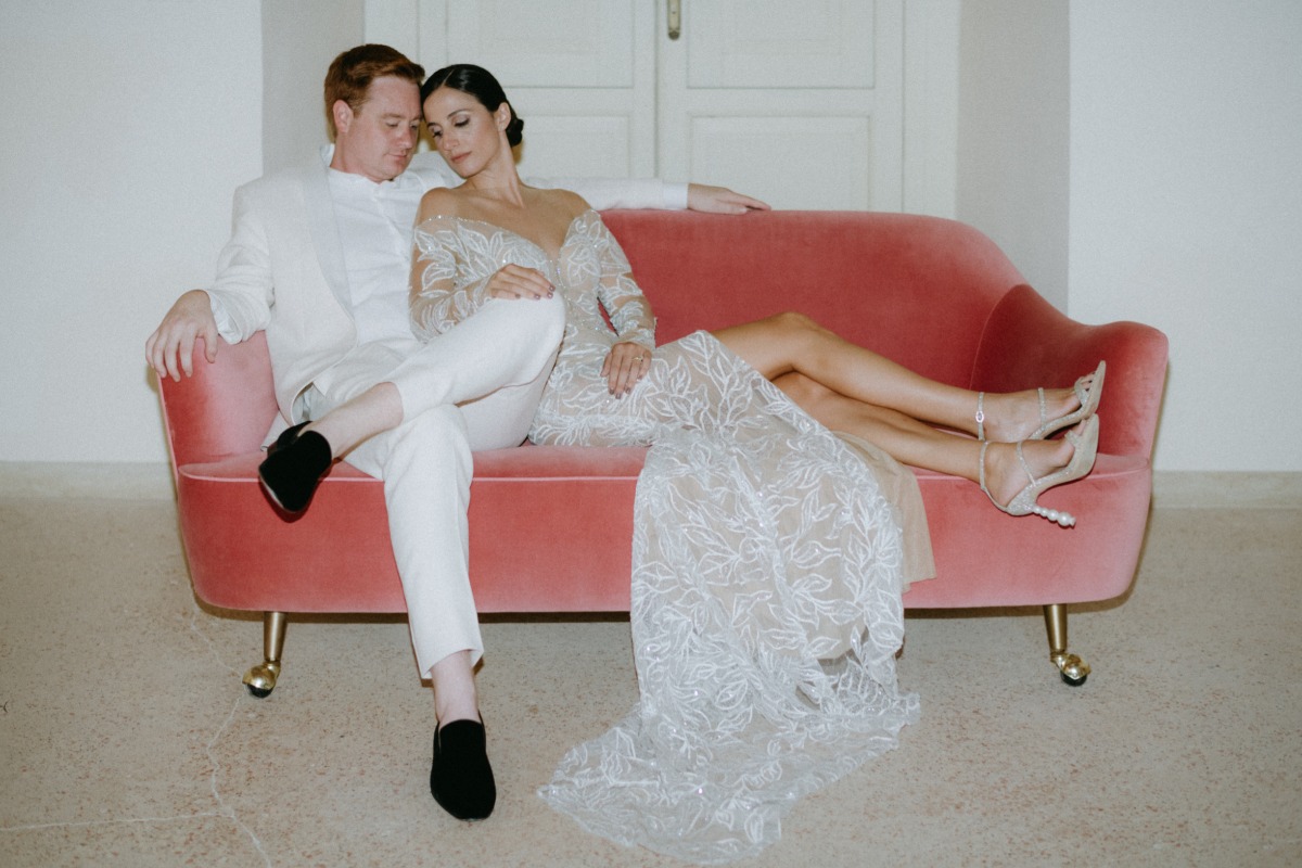 bride and groom on a pink couch