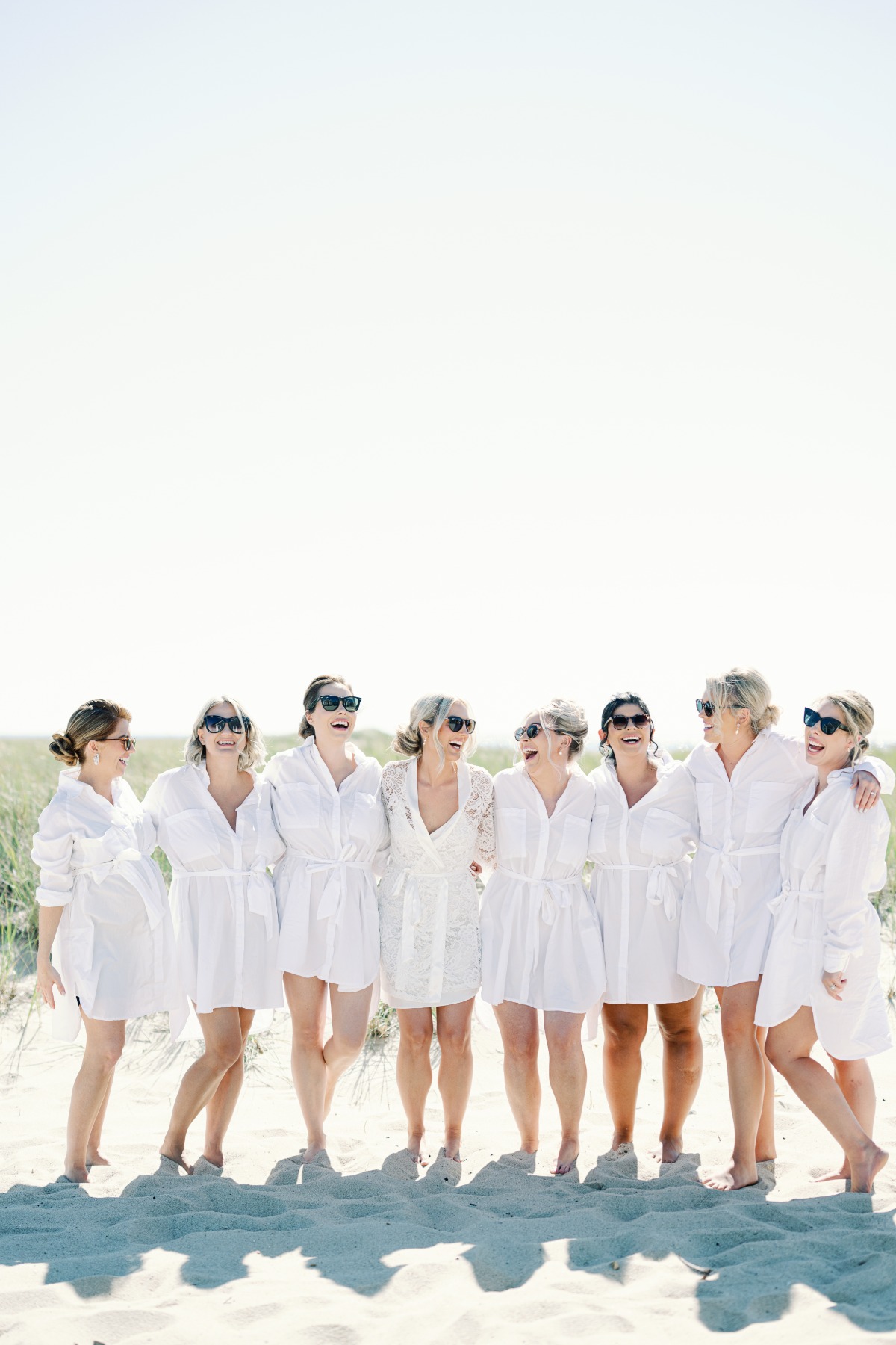 bridesmaids on robes on beachwearing sunglasses