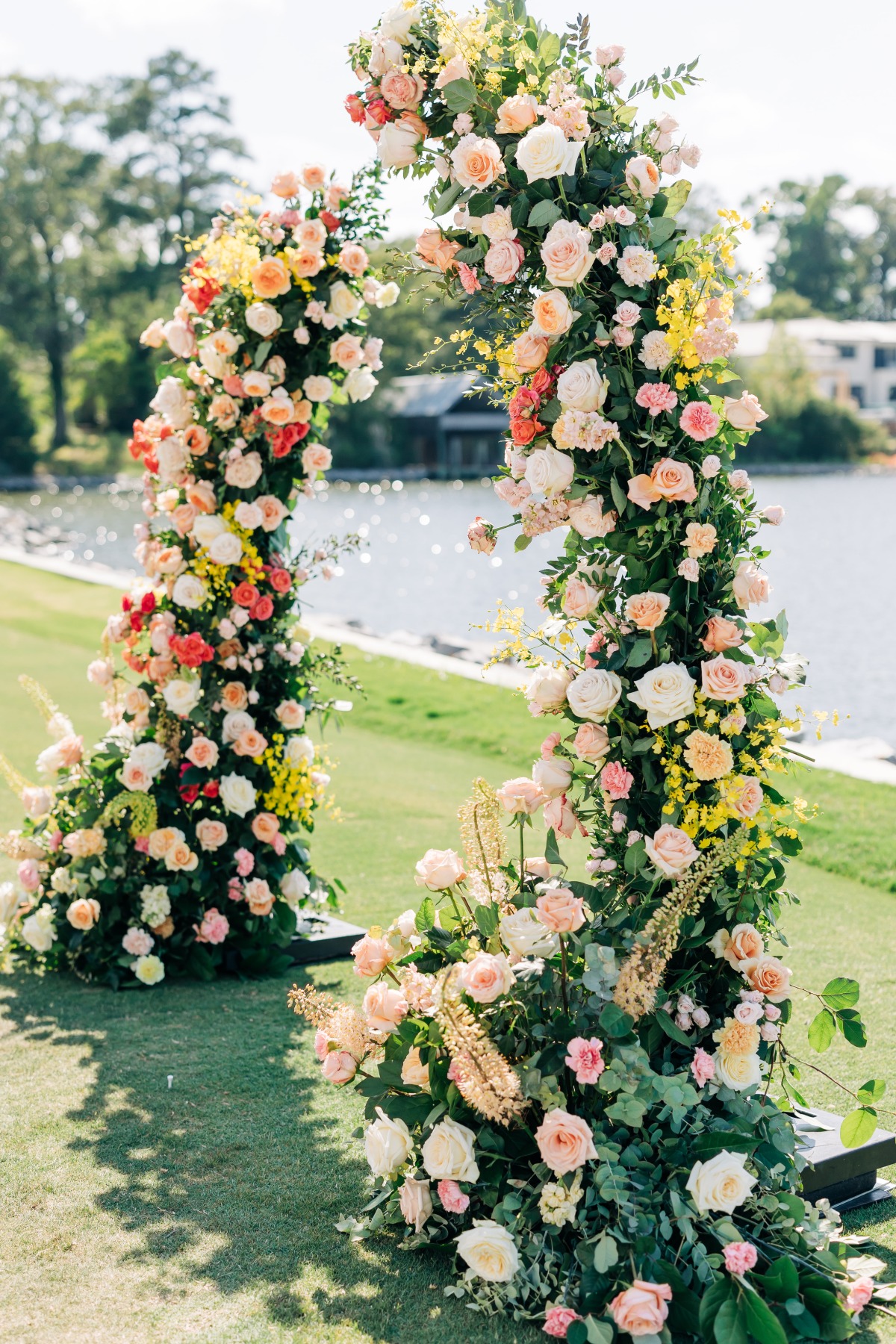 colorful wedding ceremony arch with lots of flowers